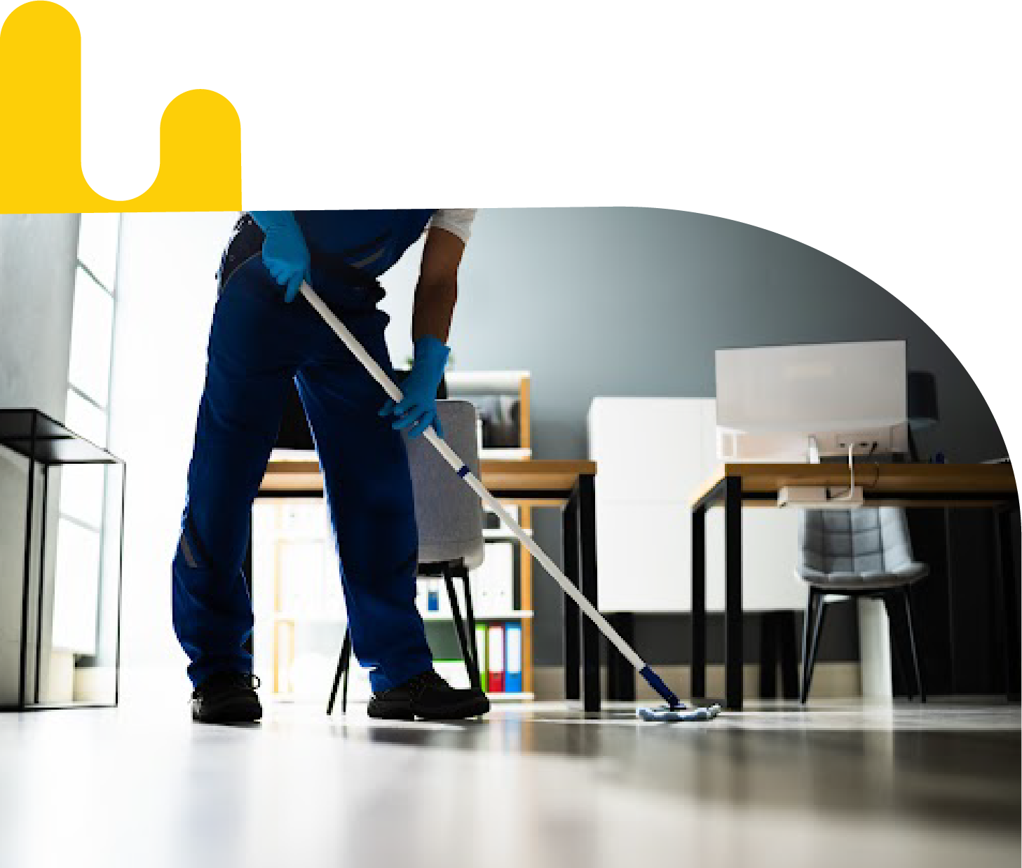 A man utilizing facility management solutions to clean a floor in an office.