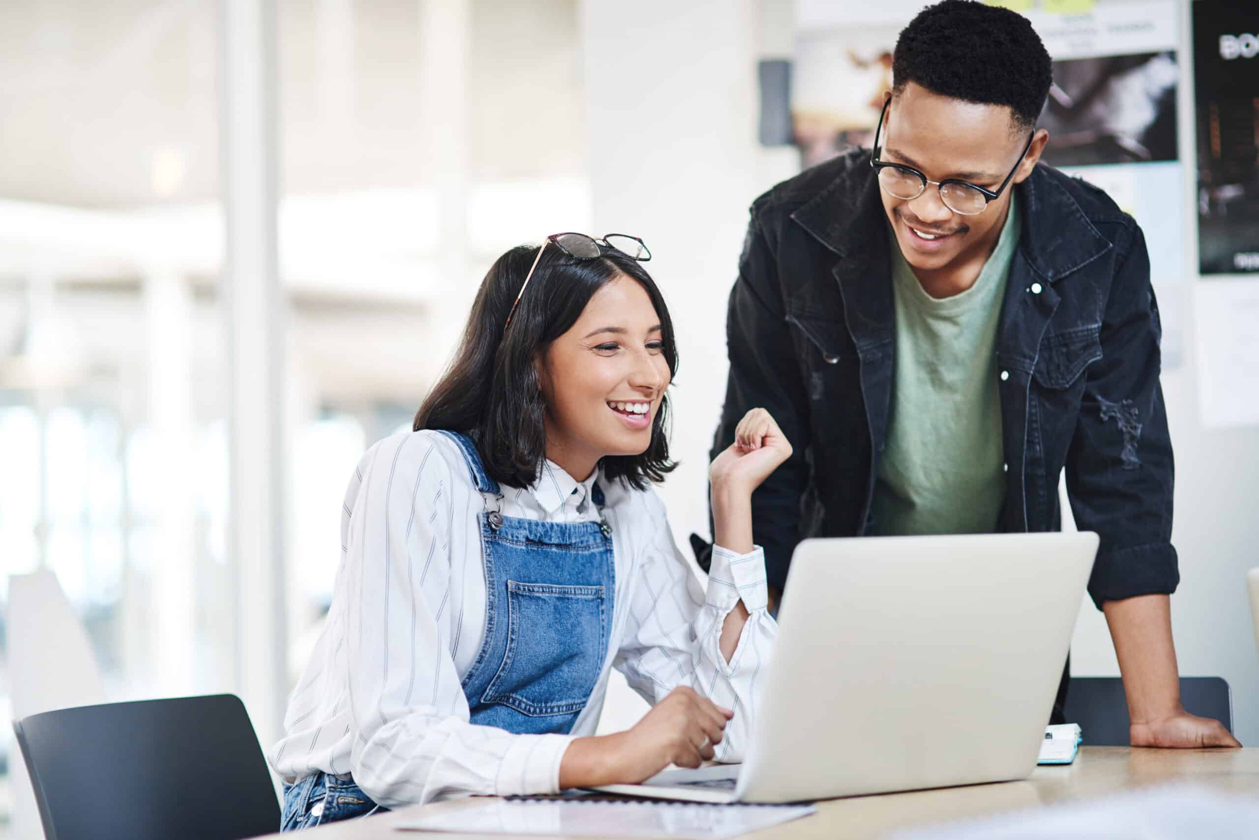 Two people using a dynamic content widget on a laptop in an office.