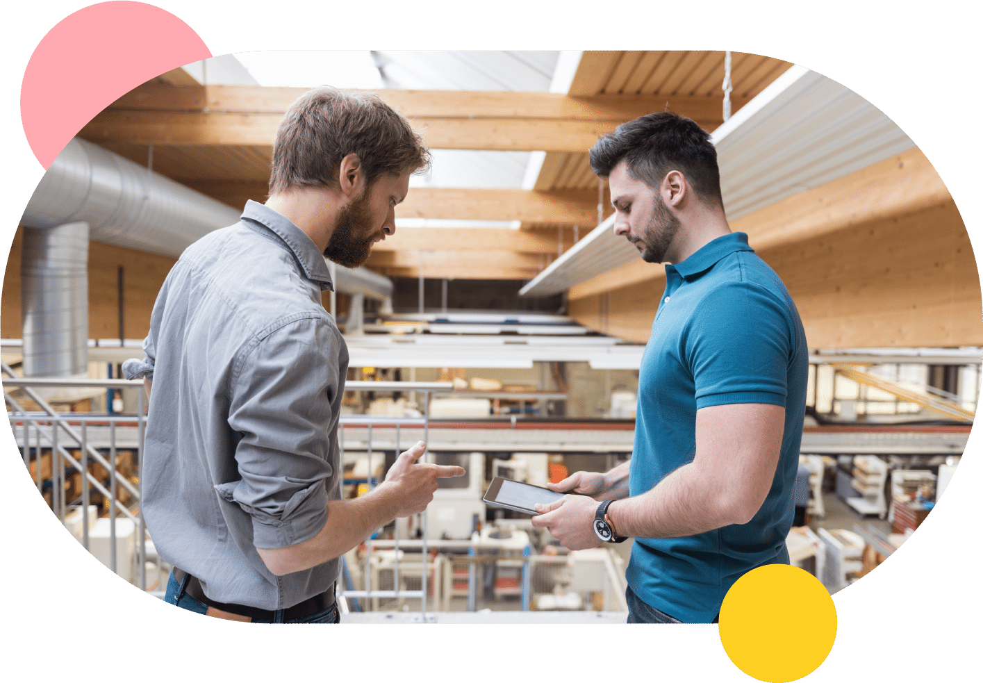 Two men discussing work orders in a factory.