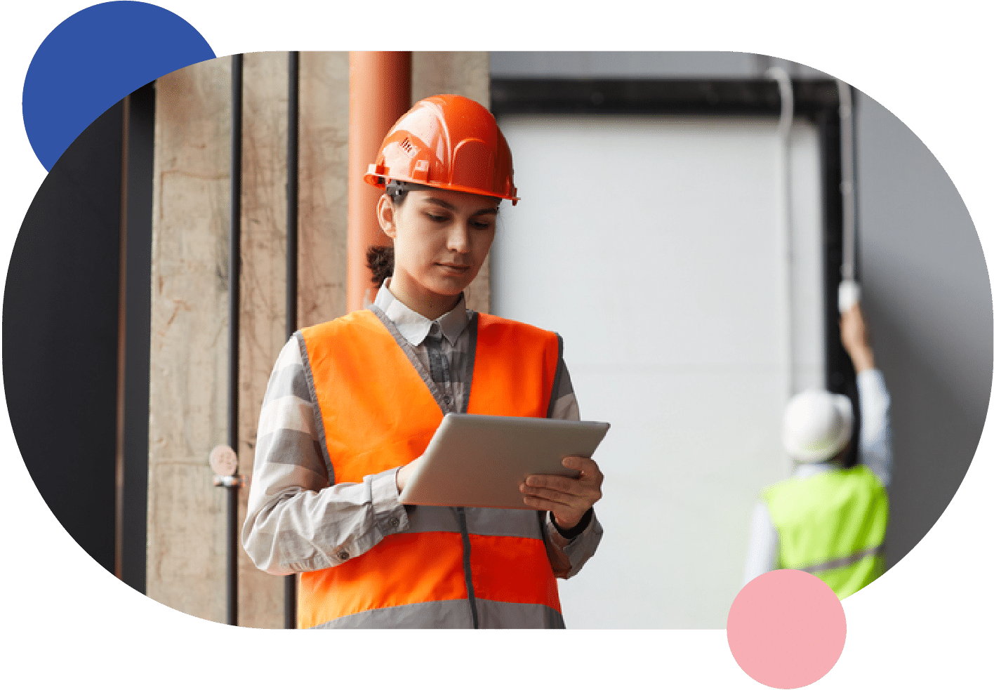 A construction worker holding a tablet in front of a rented building.