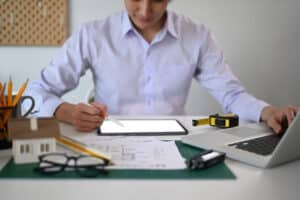 Engineer man using digital tablet and working with drawings inspection at office.