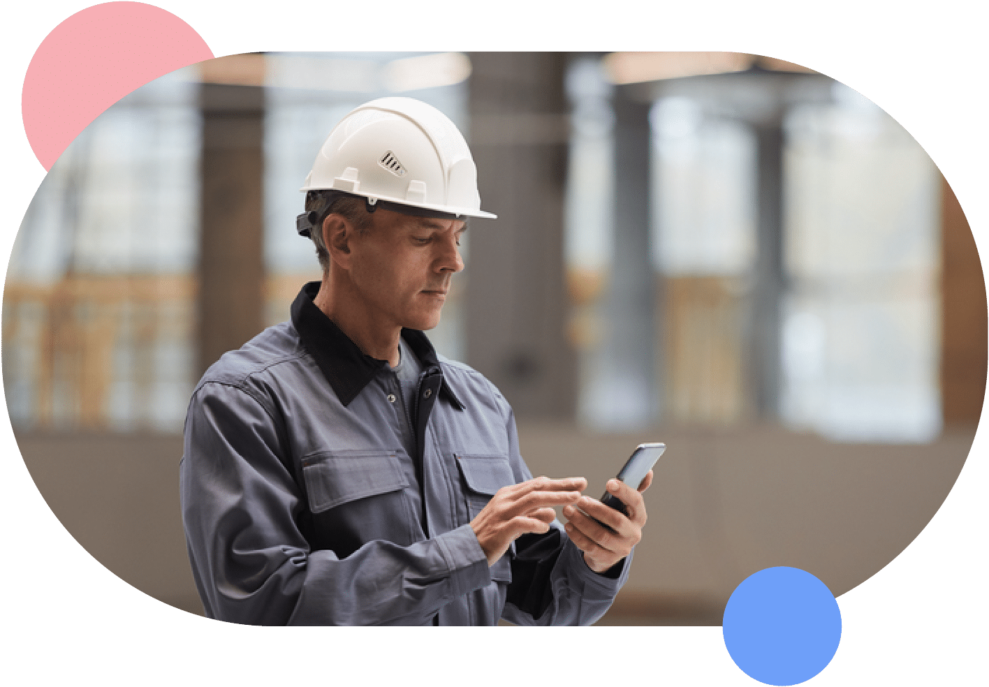 A man in a hard hat overseeing facility rentals while looking at his phone.