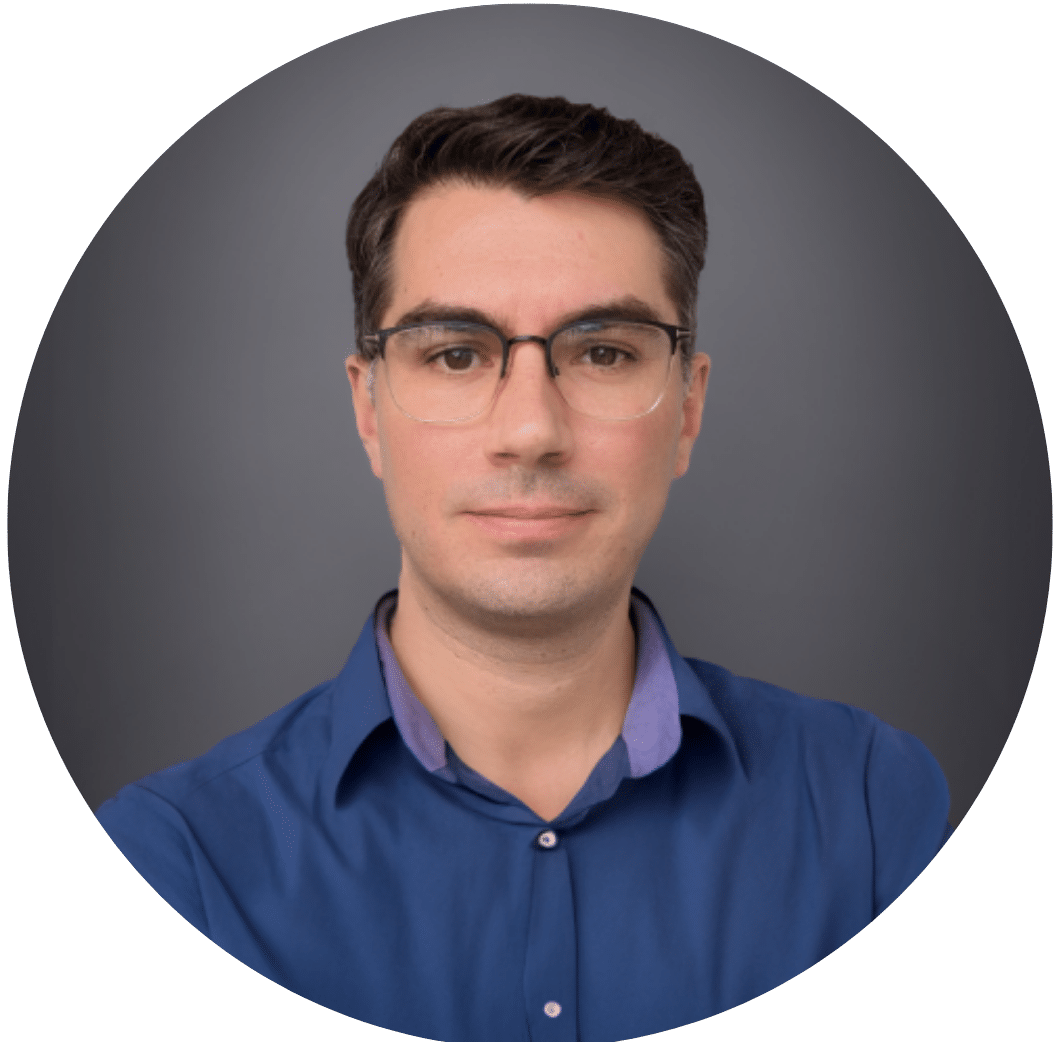 A professional headshot of a man with short dark hair and glasses, wearing a blue shirt, against a gray background. He is looking directly at the camera with a neutral expression, suitable for academic lectures