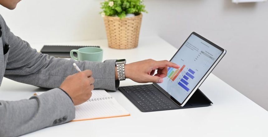 A businessman is using a realtime software on an iPad to manage timesheets.